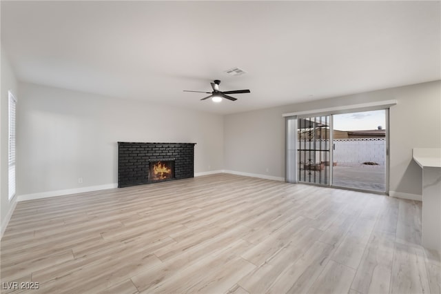 unfurnished living room with light wood-type flooring, baseboards, a ceiling fan, and visible vents