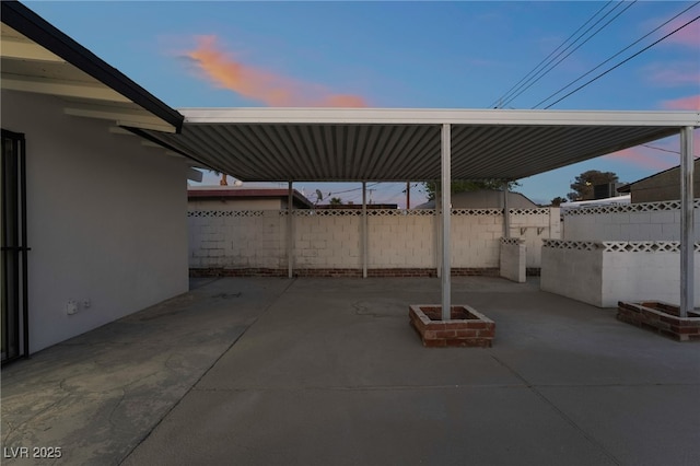 patio terrace at dusk featuring fence