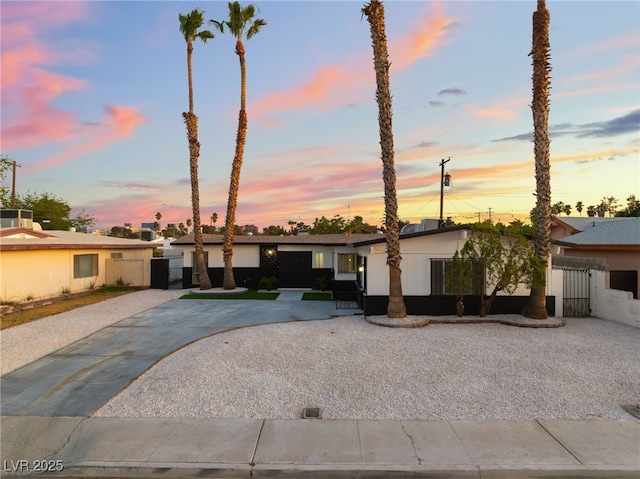 view of front of home featuring fence, a gate, and driveway