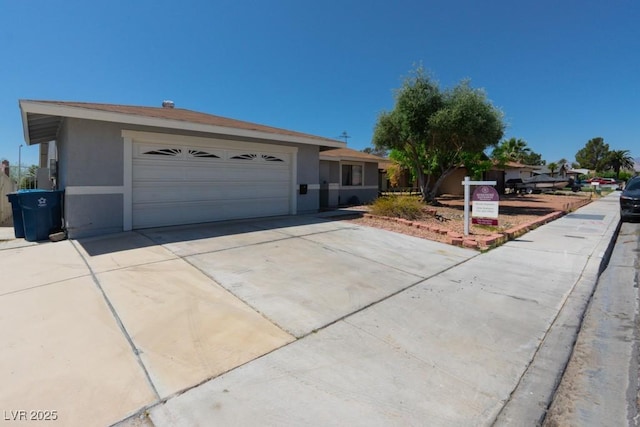 single story home with a garage, stucco siding, and driveway