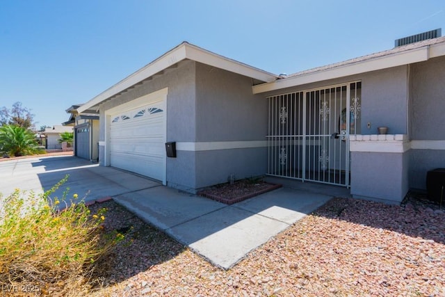view of property exterior with concrete driveway, an attached garage, and stucco siding
