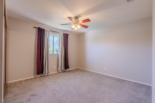 empty room with carpet flooring, baseboards, and a ceiling fan
