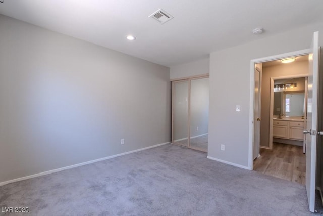 unfurnished bedroom featuring a closet, recessed lighting, baseboards, carpet flooring, and visible vents