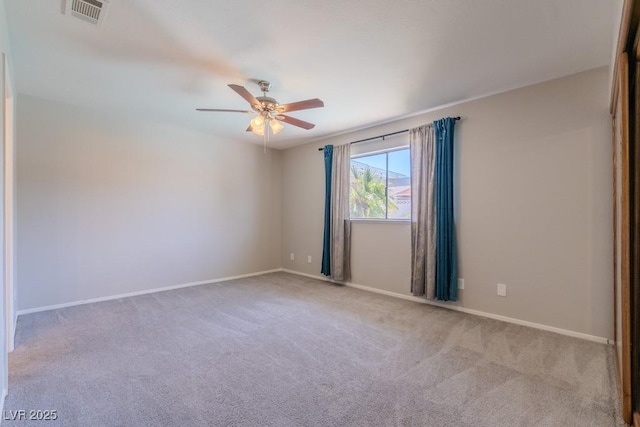 carpeted spare room featuring ceiling fan, baseboards, and visible vents