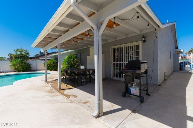 view of pool with a patio, fence, a fenced in pool, and grilling area