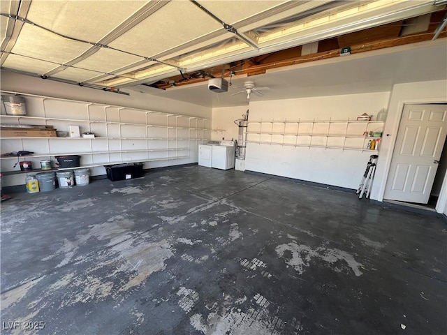 garage with independent washer and dryer and a garage door opener