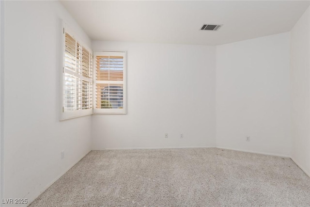 empty room featuring carpet and visible vents