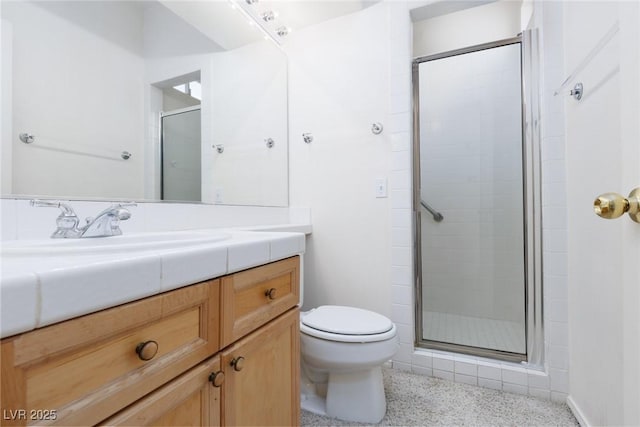 full bathroom featuring speckled floor, toilet, a stall shower, and vanity