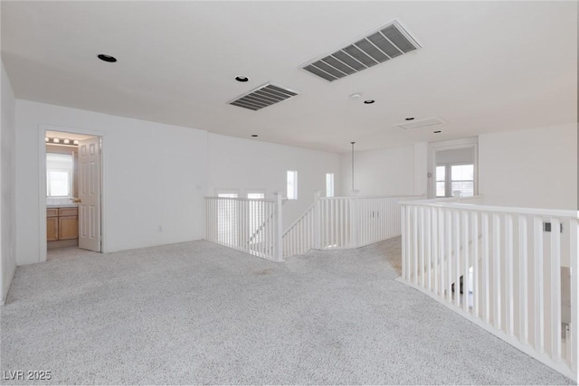 unfurnished room featuring light colored carpet and visible vents