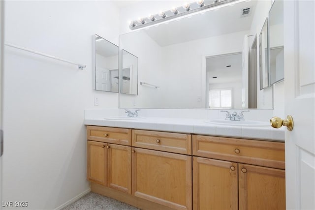 bathroom featuring double vanity, visible vents, and a sink