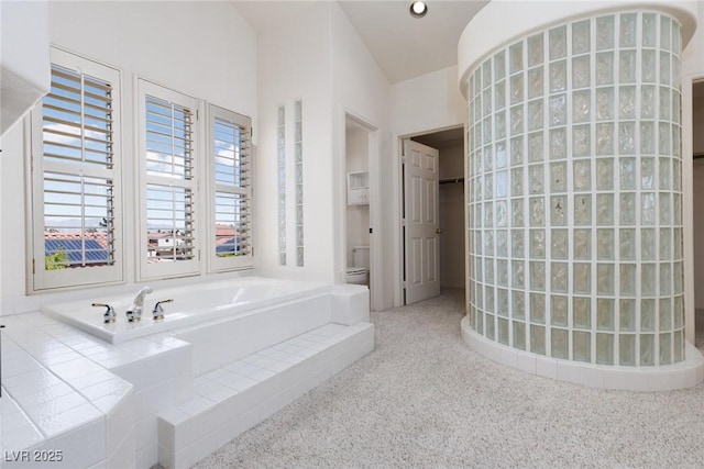 full bath featuring toilet, walk in shower, and a garden tub