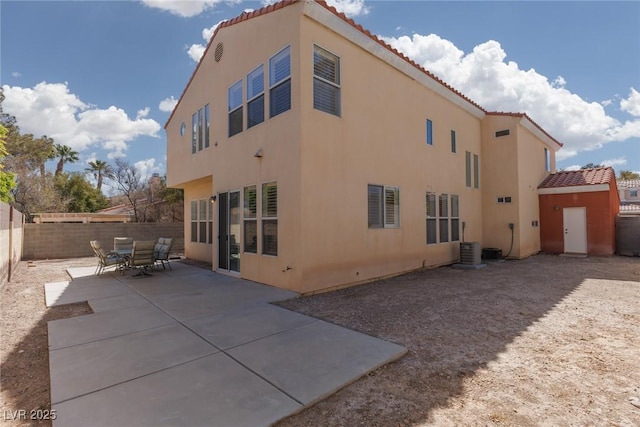 rear view of property with a patio area, stucco siding, a tiled roof, and a fenced backyard