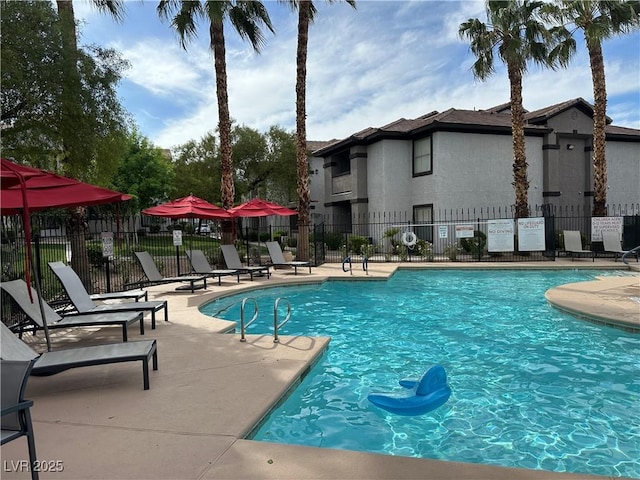 community pool with fence and a patio area