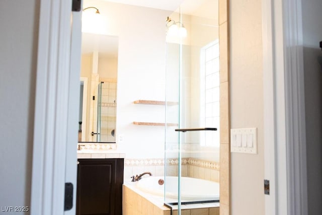 full bathroom with a relaxing tiled tub, vanity, and tiled shower