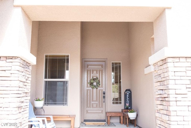 property entrance with stucco siding