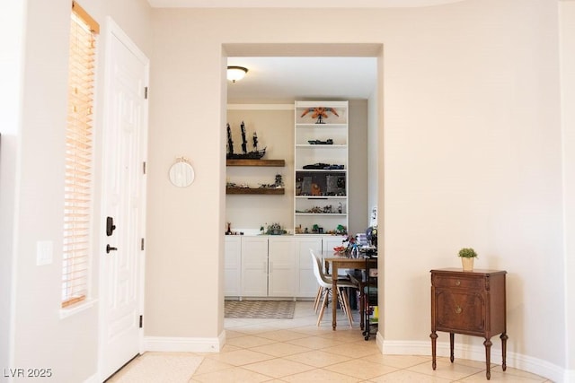 hallway featuring baseboards and light tile patterned floors