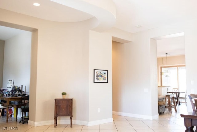 hallway with a notable chandelier, light tile patterned flooring, and recessed lighting