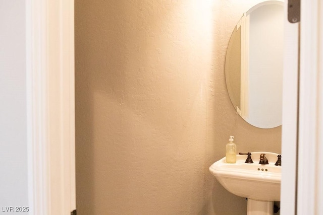 bathroom with a textured wall and a sink