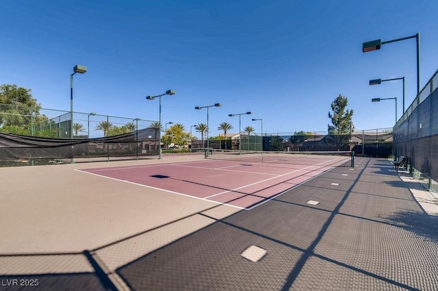 view of tennis court with fence and community basketball court