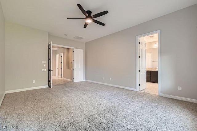 3908 Specula Wing Dr, North Las Vegas, NV 89084 - unfurnished bedroom with light colored carpet, connected bathroom, and a ceiling fan