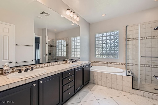 3908 Specula Wing Dr, North Las Vegas, NV 89084 - bathroom featuring a shower stall, double vanity, a garden tub, tile patterned floors, and recessed lighting
