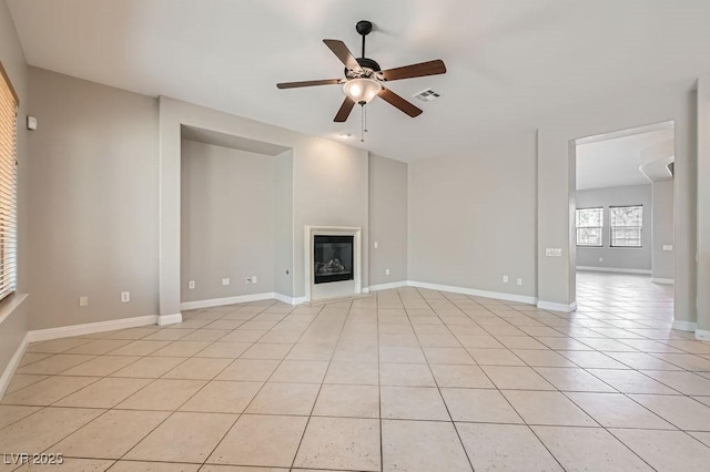 3908 Specula Wing Dr, North Las Vegas, NV 89084 - unfurnished living room featuring ceiling fan, light tile patterned floors, and a glass covered fireplace
