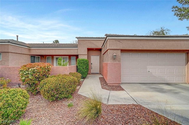 view of front of property featuring a garage, driveway, and stucco siding