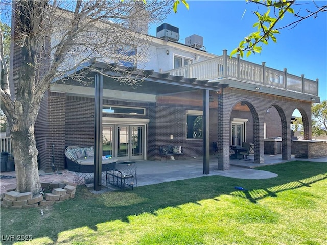 8690 W Ford Ave, Las Vegas, NV 89148 - back of house featuring french doors, brick siding, a balcony, a lawn, and a patio area