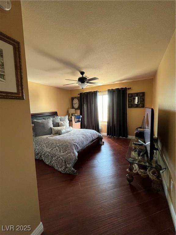 8690 W Ford Ave, Las Vegas, NV 89148 - bedroom with dark wood-style floors, baseboards, ceiling fan, and a textured ceiling