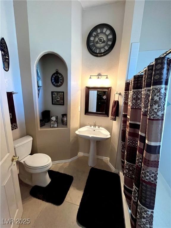 8690 W Ford Ave, Las Vegas, NV 89148 - bathroom featuring toilet, tile patterned flooring, and curtained shower