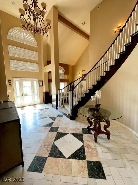 8690 W Ford Ave, Las Vegas, NV 89148 - foyer featuring a towering ceiling, stairs, baseboards, and a chandelier