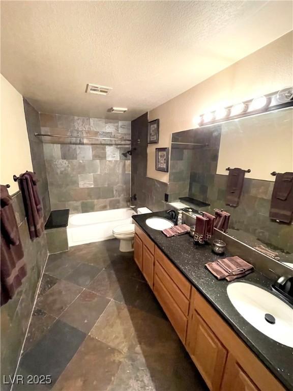 8690 W Ford Ave, Las Vegas, NV 89148 - full bath with double vanity, toilet, a textured ceiling, and shower / bathtub combination