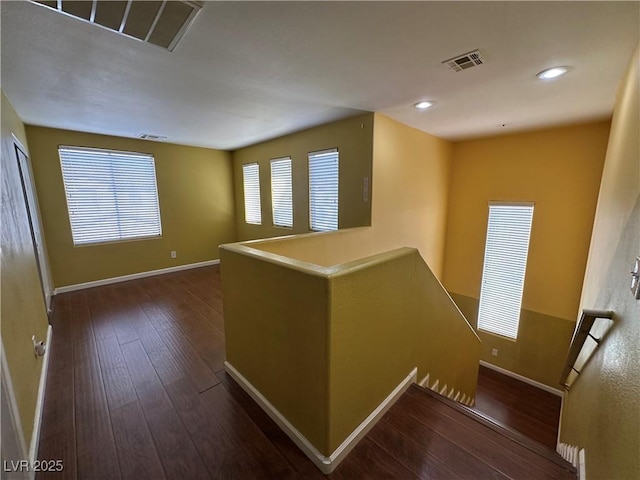 interior space featuring visible vents, baseboards, an upstairs landing, recessed lighting, and hardwood / wood-style floors