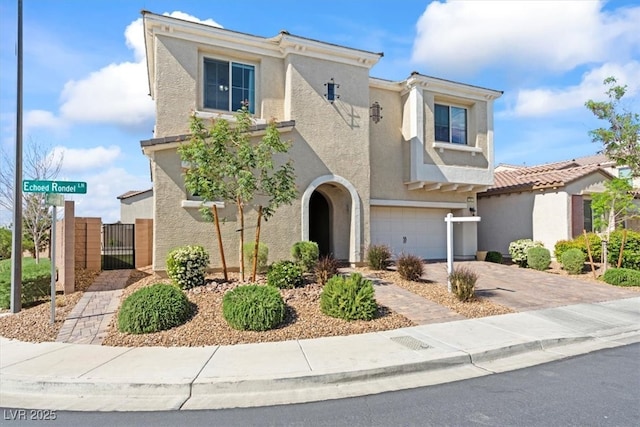 view of front of home featuring a garage, a gate, stucco siding, and driveway