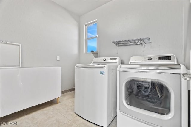 laundry room with separate washer and dryer, light tile patterned flooring, and baseboards