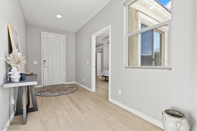 foyer entrance with wood finished floors and baseboards