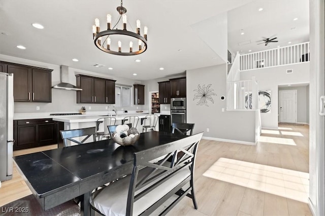 dining area featuring a chandelier, light wood-type flooring, recessed lighting, a ceiling fan, and baseboards
