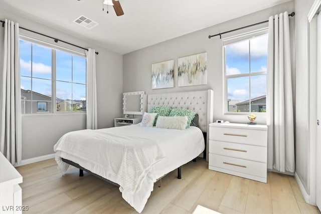 bedroom with light wood-style flooring, baseboards, and ceiling fan