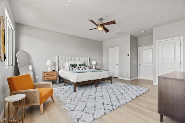 bedroom with light wood-type flooring, baseboards, and a ceiling fan