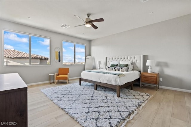 bedroom featuring light wood-style flooring, baseboards, and multiple windows