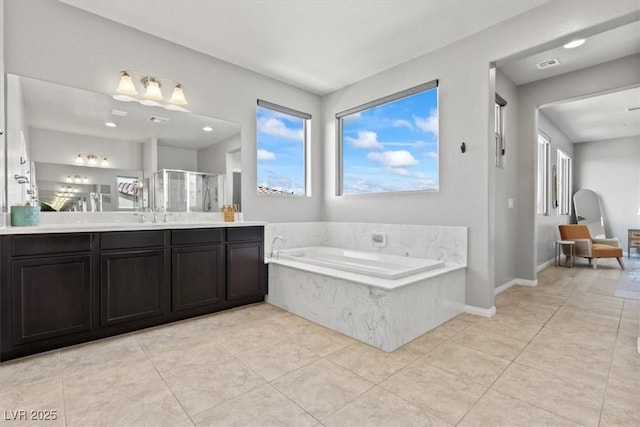 bathroom featuring tile patterned floors, a garden tub, vanity, a stall shower, and baseboards