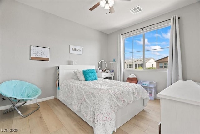 bedroom featuring light wood finished floors, baseboards, and ceiling fan