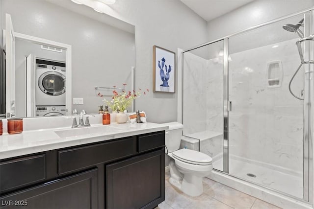 full bath with stacked washing machine and dryer, a marble finish shower, tile patterned floors, and toilet