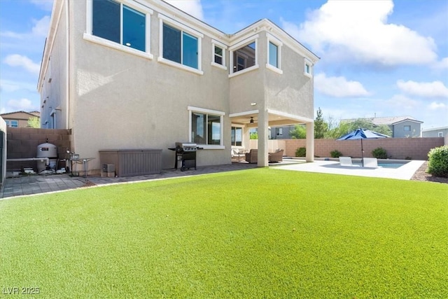 back of property with a patio area, ceiling fan, stucco siding, and an outdoor living space
