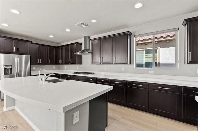 3062 Echoed Rondel Ln, Henderson, NV 89044 - kitchen featuring wall chimney exhaust hood, light countertops, light wood-style flooring, recessed lighting, and a kitchen island with sink