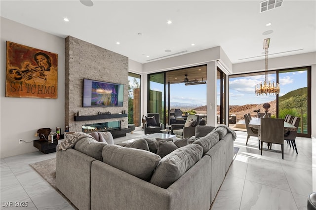 387 Solitude Peak Ln, Henderson, NV 89012 - living room with visible vents, an inviting chandelier, marble finish floor, and a fireplace