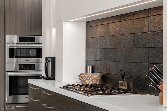 387 Solitude Peak Ln, Henderson, NV 89012 - kitchen featuring dark brown cabinets, modern cabinets, light countertops, tasteful backsplash, and stainless steel appliances