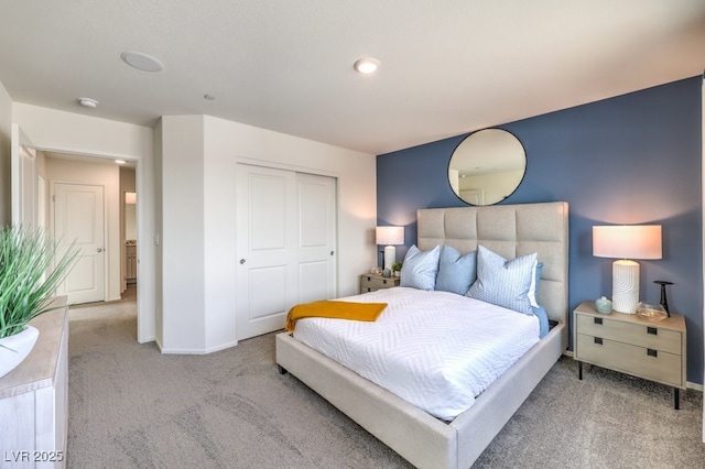 carpeted bedroom featuring a closet and baseboards