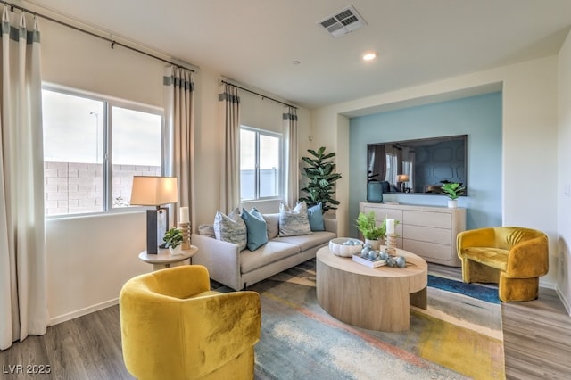living area with wood finished floors, baseboards, visible vents, and recessed lighting
