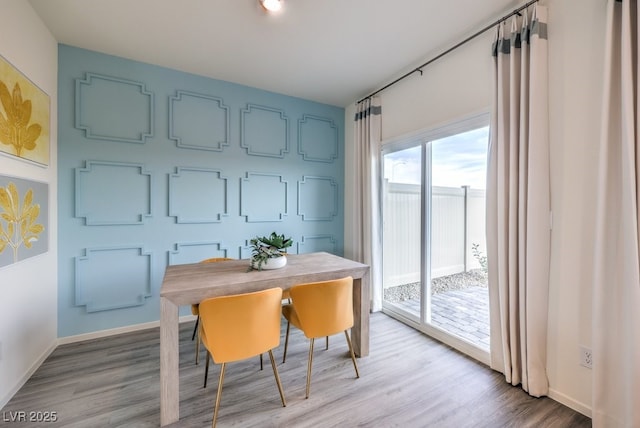 dining space with baseboards and light wood finished floors